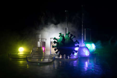 Corona virus Vaccine concept with syringe and green Corona virus novel miniature. Vaccine Concept of fight against coronavirus. Creative decoration with fog and backlight. Selective focusの写真素材