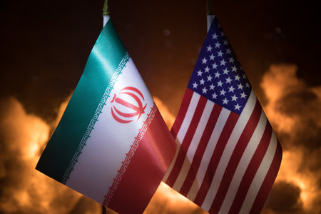 USA and Iran small flags on burning dark background. Concept of crisis of war and political conflicts between nations. Selective focusの写真素材