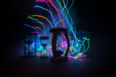 Time concept. Silhouette of Hourglass clock on dark toned background. Abstract concept with copy space. Selective focusの写真素材