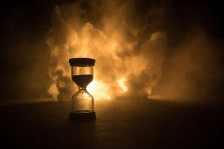 Time concept. Silhouette of Hourglass clock on dark toned background. Abstract concept with copy space. Selective focusの写真素材