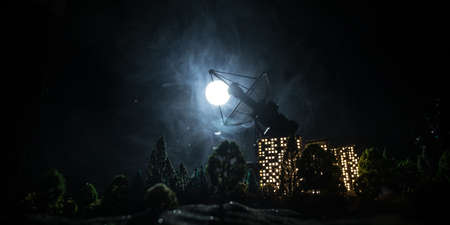 Silhouettes of satellite dishes or radio antennas against night sky. Space observatory or Air defence radar over dramatic night sky. Creative artwork decoration. Selective focusの写真素材