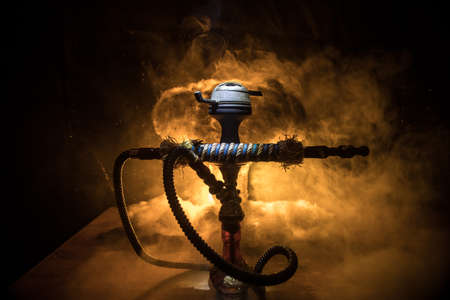 Shisha Concept. Hookah hot coals on shisha bowl with black background. Stylish oriental shisha with colorful lights. Selective focusの写真素材