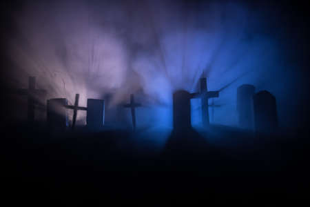 Scary view of zombies at cemetery dead tree, moon, church and spooky cloudy sky with fog, Horror Halloween concept. Selective focusの写真素材