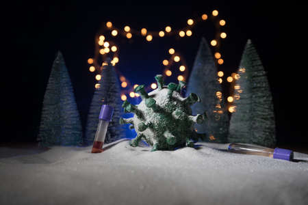 Celebrating winter and Christmas holidays in the new Covid-19 reality. Traditional holiday attributes and covid novel on snow. Creative artwork decoration. Merry healthy Christmasの写真素材