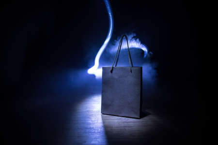 Shopping concept. Brown shopping bag with handles placed on dark desktop. Selective focus