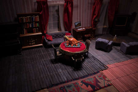 Thanksgiving holiday creative concept. A realistic dollhouse living room with furniture and window at night. Thanksgiving Turkey miniature on table. Selective focusの写真素材