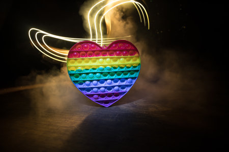 kids anti stress sensory simple dimple fidget push toys on a dark background with light and fog.の写真素材