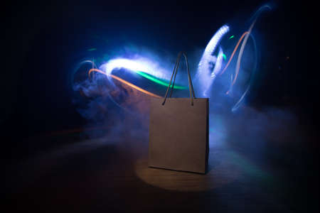 Shopping concept. Brown shopping bag with handles placed on dark desktop. Selective focus