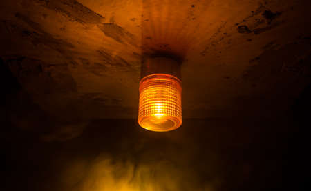Emergency lighting in the factory, Warning light, Orange siren on concrete wall. Rotating siren.