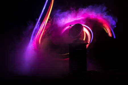 Silhouettes of satellite dishes or radio antennas against night sky. Space observatory or Air defense radar over dramatic night sky. Creative artwork decoration. Selective focusの写真素材