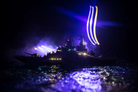 War concept. Night battle scene at sea. Dramatic toned clouds effect. Silhouette of the battle ship in night. Miniature creative table decoration. Selective focusの写真素材