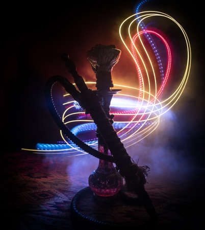 Shisha Concept. Hookah hot coals on shisha bowl with black background. Stylish oriental shisha with colorful lights. Selective focusの写真素材
