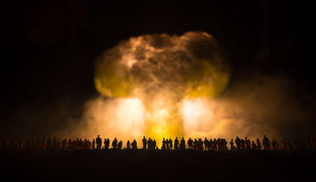 Nuclear war concept. Explosion of nuclear bombs. Creative artwork decoration in dark. People looking at giant mushroom cloud of atomic explosion. selective focusの写真素材