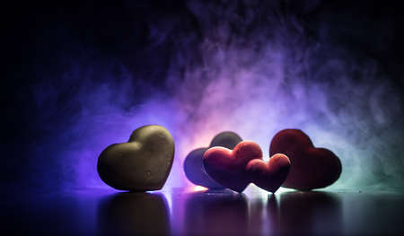 Valentines background. Valentine's Day heart on a dark wooden table. Burning hearts. Heart in fire. Dark toned foggy background. Selective focusの写真素材
