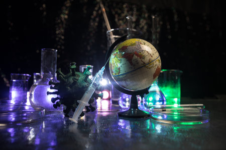 virus Vaccine concept with syringe and green virus novel miniature. Vaccine Concept of fight against virus. Creative decoration with fog and backlight. Selective focusの写真素材