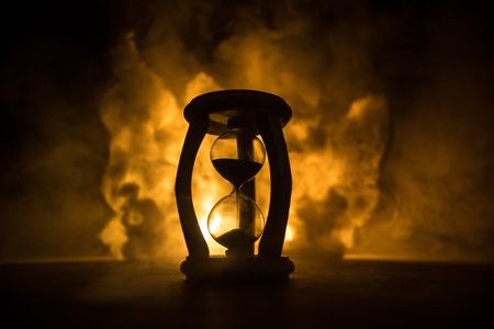 Time concept. Silhouette of Hourglass clock on dark toned background. Abstract concept with copy space. Selective focusの写真素材