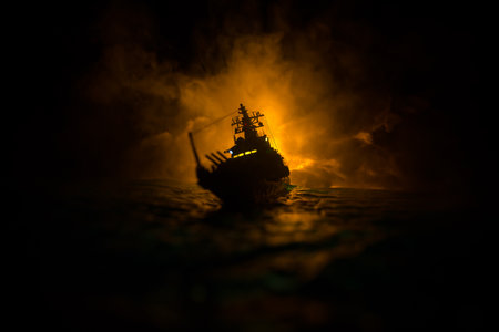 War concept. Night battle scene at sea. Dramatic toned clouds effect. Silhouette of the battle ship...