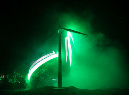 Electricity power in nature or clean energy concept. Wind Turbine producing alternative energy on hill at night. Creative decoration with small miniature. Selective focusの写真素材