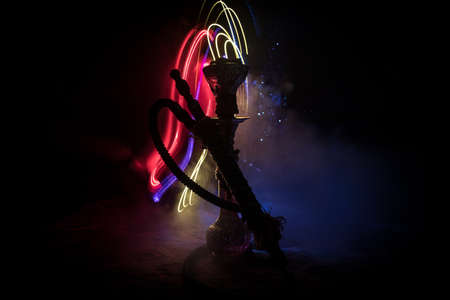Shisha Concept. Hookah hot coals on shisha bowl with black background. Stylish oriental shisha with colorful lights. Selective focusの写真素材