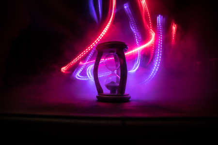 Time concept. Silhouette of Hourglass clock on dark toned background. Abstract concept with copy space. Selective focusの写真素材