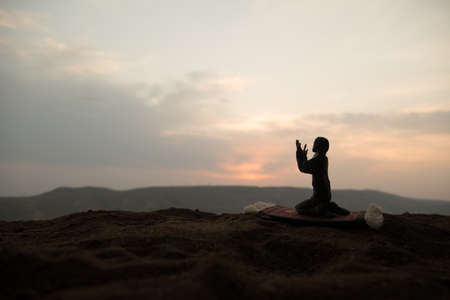Silhouette of muslim prayer on sunset. Ramadan Kareem background. Praying people. selective focusの写真素材