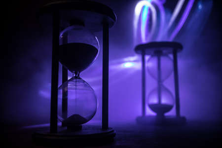 Time concept. Silhouette of Hourglass clock on dark toned background. Abstract concept with copy space. Selective focusの写真素材