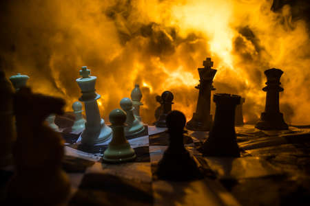 Chess board game concept of business ideas and competition or war theme. Chess figures on a dark background of explosion and fire clouds. selective focusの写真素材