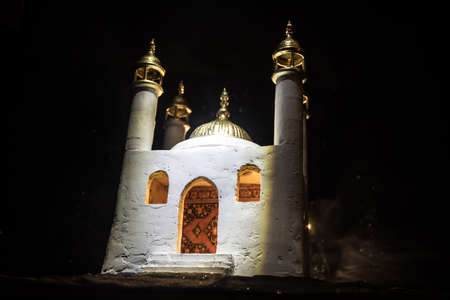 A realistic Mosque miniature with windows at night. Festive greeting card, invitation for Muslim holy month Ramadan Kareem. selective focusの写真素材