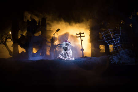 The death of children in the war. Russian war in Ukraine concept. Creative artwork of little doll lies on ground in burned out city. selective focusの写真素材