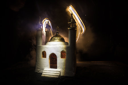 A realistic Mosque miniature with windows at night. Festive greeting card, invitation for Muslim holy month Ramadan Kareem. selective focusの写真素材