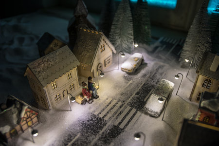 Little decorative cute small houses in snow at night in winter, Christmas and New Year miniature house in the snow at night with fir tree. Holiday concept. Selective focusの写真素材
