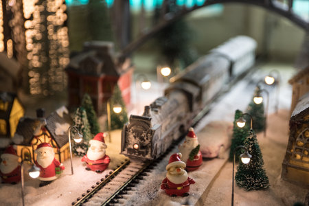 Miniature of winter scene with Christmas houses, train station, trees, covered in snow. night scene. New year vintage toy city. selective focusの写真素材