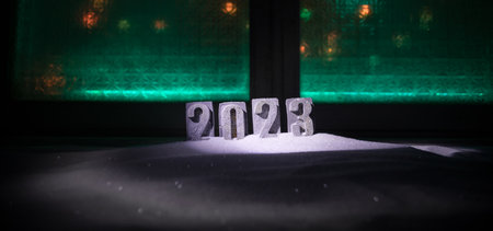 Happy New Year 2023. Traditional holiday attributes on snow. A greeting card for Christmas....