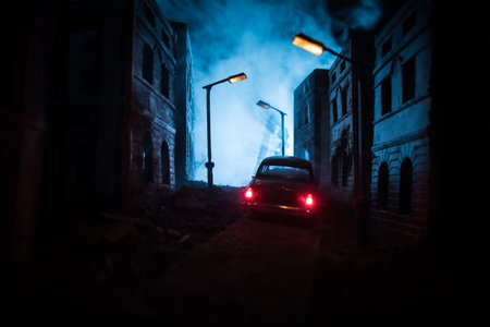 Silhouette of old vintage car in dark foggy abandoned city with glowing lights, or silhouette of old crime car dark background. selective focusの写真素材