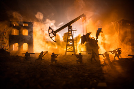 art decoration. Oil war concept. Military silhouettes at oilfield with pumps and rigs. misty colorful sky background. Armored vehicles fighting scene. selective focusの写真素材