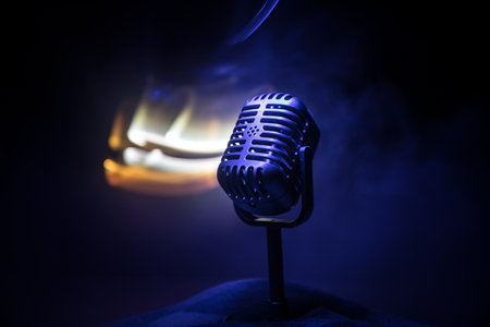 Microphone for sound, music, karaoke in audio studio or stage. Mic technology. Speech broadcast equipment. Microphone in dark room on table with backlight. selective focusの写真素材