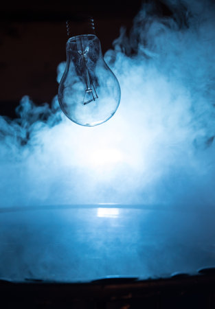 abstract concept. Light bulb dropping on water or water splash on dark foggy background. selective focus.の写真素材