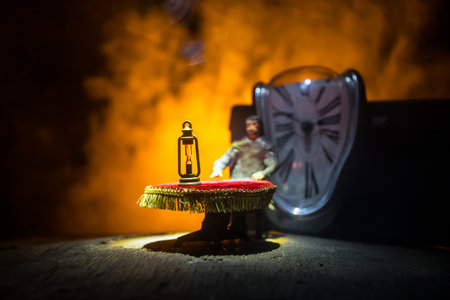 time concept. Man sitting on table with hourglass. Abstract hourglasses with smoke and lights on a dark background. Surreal decorated pictureの写真素材