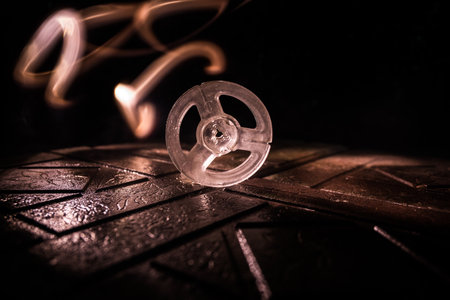 Plastic empty bobbin on dark toned background with light. music concept. selective focus