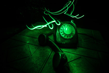 old red telephone on grunge stone surface with art dark background with fog and toned light. empty space. selective focusの写真素材