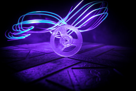 Plastic empty bobbin on dark toned background with light. music concept. selective focusの写真素材