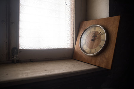time concept. Old rustic wall clock on grunge dirty windowsill. studio shot.の写真素材