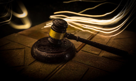 Law theme, mallet of the judge on wooden desk. Law gavel on dark foggy background with light. selective focusの写真素材