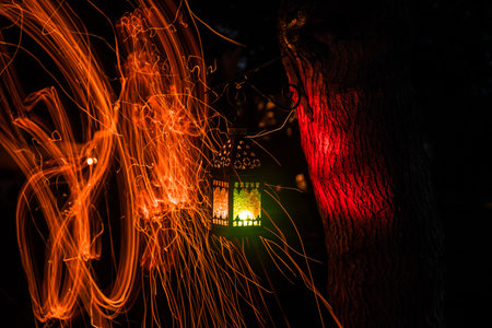 Beautiful colorful illuminated lamp in the garden in misty night. Retro style lantern at night outdoor. selective focusの写真素材