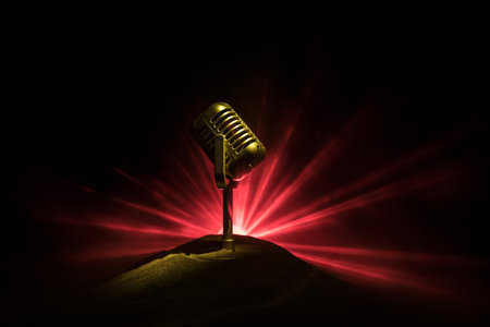 Microphone for sound, music, karaoke in audio studio or stage. Mic technology. Speech broadcast equipment. Microphone in dark room on table with backlight. selective focusの写真素材