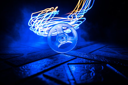 Plastic empty bobbin on dark toned background with light. music concept. selective focusの写真素材