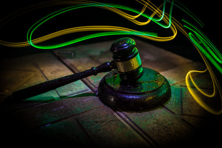Law theme, mallet of the judge on wooden desk. Law gavel on dark foggy background with light. selective focusの写真素材
