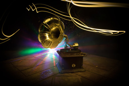 music concept. Old gramophone on a dark background. Retro gramophone with disc on wooden table with toned backlight. selective focusの写真素材