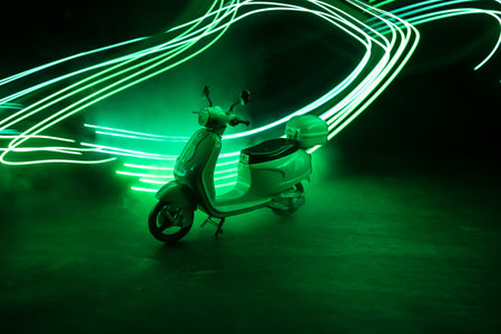Silhouette of scooter miniature standing on dark background with light. selective focusの写真素材