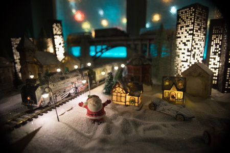 Miniature of winter scene with Christmas houses, train station, trees, covered in snow. night scene. New year vintage toy city. selective focusの写真素材
